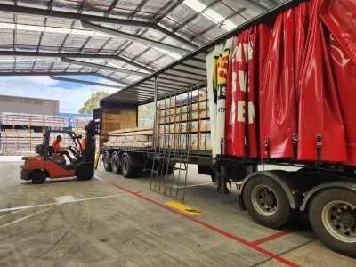 Forklift loading break-bulk cartons into a DSE Transport tautliner with the side curtain open