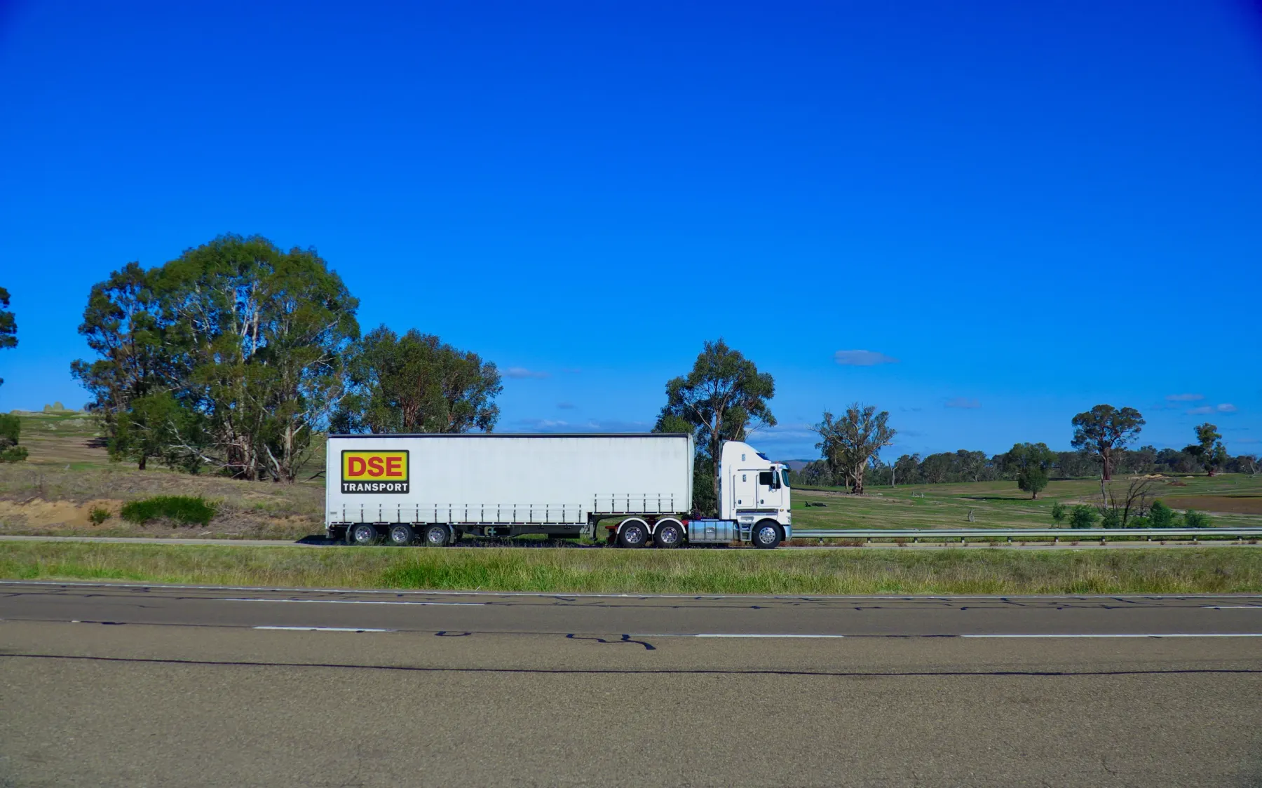 DSE Transport Kenworth curtain-sider running an interstate linehaul leg on a country highway