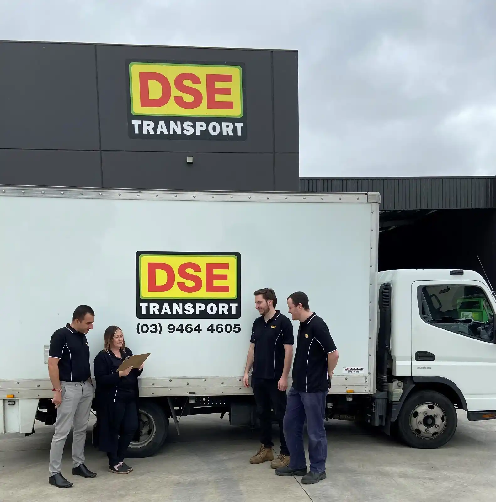 DSE Transport Victoria team members in uniform beside a DSE truck at the Campbellfield branch